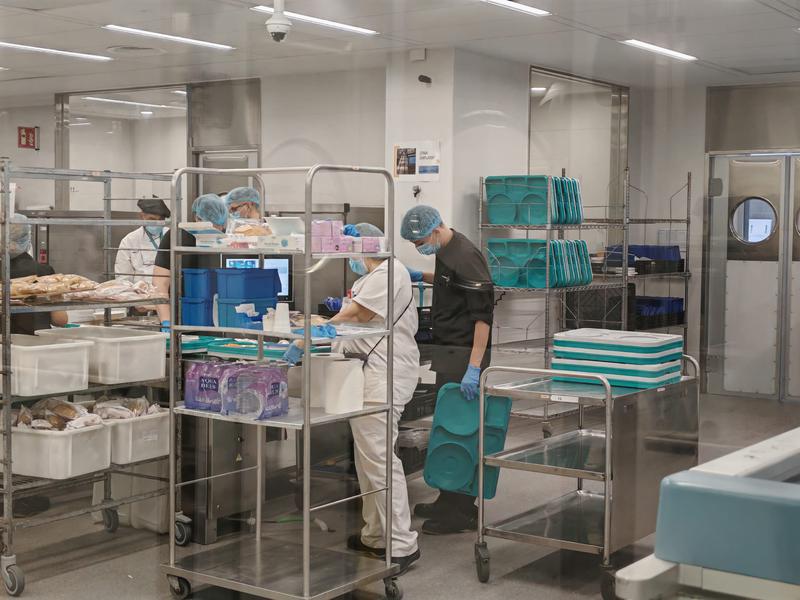 Treballadors de l'Hospital Germans Trias i Pujol preparant les safates per als pacients